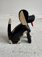 Side view of carved wooden dog showing tail and body paint
