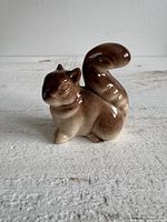 Front view of brown glazed ceramic squirrel figurine on white surface