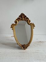 Full view of oval vanity mirror showing ornate frame and reflective glass