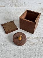 Open cube box, slide lid removed, spinning top displayed