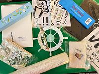 All items laid out showing decals, ship wheel, pouches, boards, sticker sheet