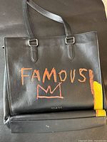 Front view of Coach tote showing painted graphic and straps