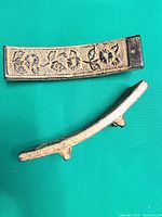 Two incense burners showing curved shape, antiqued gold finish, support feet