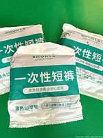 Three sealed disposable shorts packs on green background