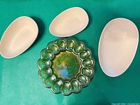 overhead view of green carnival glass deviled-egg plate with three white bowls
