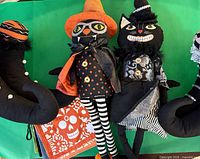 Two character plush dolls and portion of boot pillows against green background