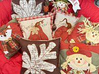 Group shot of all seven fall-themed pillows on red background