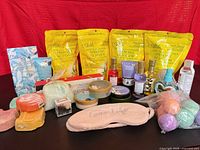 Full lot overview showing Epsom salt pouches, bath bombs, body butters, soaps, small bottles, eye mask
