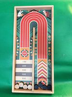 Top view of wooden board with divider and eight discs showing play surface graphics