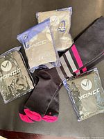 Lot overview showing four packaged YQXCC cooling towels and black socks with pink and grey accents