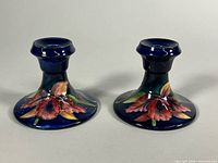 Front view of both Moorcroft candlesticks showing floral design and color