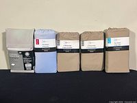 Five unopened bedding packages lined up