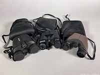 Three binoculars with carry cases front view