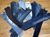 All twelve pairs arranged on wood floor showing variety of washes