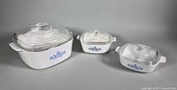 Three CorningWare Blue Cornflower casseroles with lids displayed