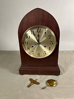 Front view of beehive mantel clock with key and pendulum