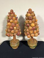 Front view of the pair of faux fruit topiaries in pots