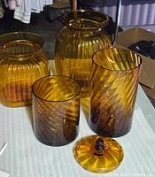 Group of four amber glass containers and loose lid