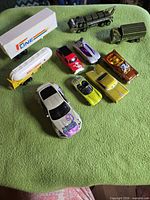 Group shot of all ten die-cast vehicles on green cloth
