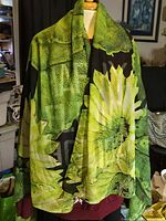 Full view of green floral scarf draped on mannequin showing pattern and size
