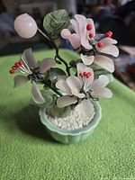 Full view of jade glass bonsai tree showing flowers, leaves, and pot