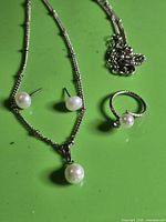 Necklace, earrings and ring displayed together