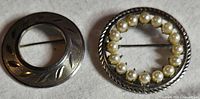 Front view of both brooches showing designs and faux pearls