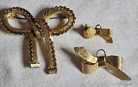 All three gold-tone bow brooches front view