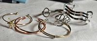 Five assorted cuff bracelets laid out