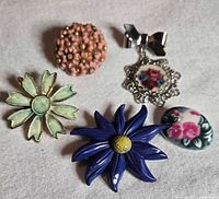 All five floral brooches laid out