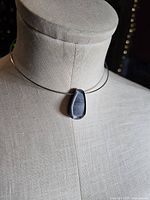 Necklace on dress form showing front view of pendant placement