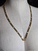 Chain displayed on mannequin bust showing link style and clasp