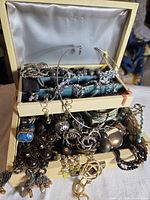 Open jewelry music box showing assorted jewelry