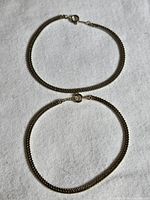 Both gold plated flat chain bracelets laid flat showing design and clasps