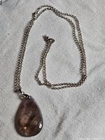 Necklace laid flat showing chain and pendant front