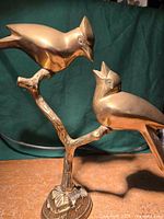 Full view of brass birds sculpture on branch showing overall form and base
