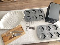 All items laid out: three muffin pans, platter, cutting board with knife and server, wire rack, metal sign