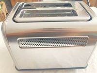 Side view of stainless Buydeem toaster showing perforated vent panel