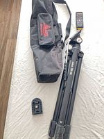 Folded Leica TRI 100 tripod, Leica shoulder bag, laser distance meter, mount plate