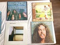 Four LP covers: Deep Purple, Elton John, Dire Straits, Ted Nugent on white surface