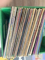 Stack of roughly 40 LPs in green crate