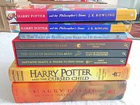 Stack of eight Harry Potter-related books showing all spines