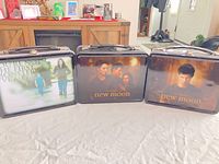 Front view of three Twilight New Moon tin lunch boxes