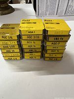 Two stacks of 20 yellow Buss fuse cases showing labels and ratings