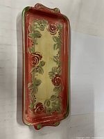Top view of rectangular ceramic tray showing painted design and handles