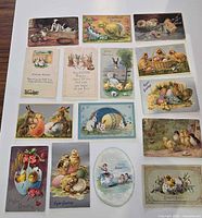Fronts of 15 rectangular and one oval Easter postcards laid out on white surface