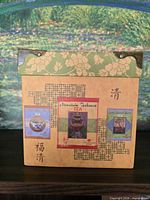 Front of box showing printed tea collage and metal corner accents