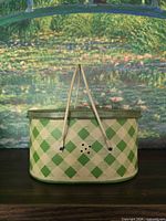 Front view of oval metal basket showing green argyle pattern and lid with handles