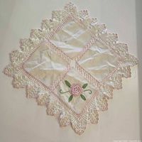 Diamond-shaped topper with pink edging and floral appliqué