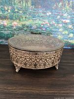 Front angle showing brass filigree sides, glass lid, feet